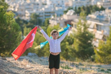 Çocuk Ukrayna bayrağını şehre karşı tutuyor. Çocuk el sallıyor Türkçe ve Ukrayna bayrak görüntüsü, metin için boşluk kopyala