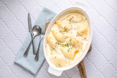 Peynirli ve kremalı tavuk ve kabuklu makarna fırında pişirme kabuğunda koyu gri beton masa üzerinde, yatay görüş yukarıdan, yakın çekim