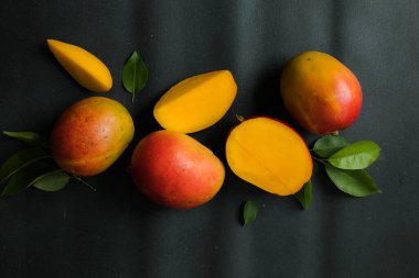 Mango arka plan tasarımı konsepti. Masada yaprakları olan taze mango meyvelerinin üst görüntüsü..