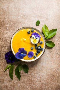 Mango Lassi, smoothie kasesi ve zerdeçal. Hafif arka planda taze tropikal meyve. Sağlıklı yemek.