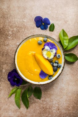 Mango Lassi, smoothie kasesi ve zerdeçal. Hafif arka planda taze tropikal meyve. Sağlıklı yemek.