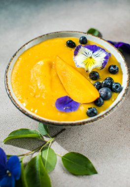 Mango Lassi, smoothie kasesi ve zerdeçal. Hafif arka planda taze tropikal meyve. Sağlıklı yemek.