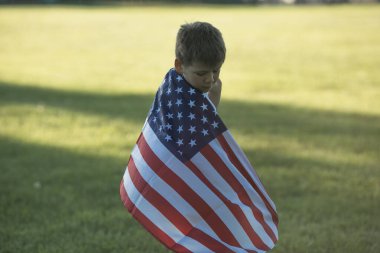 Çocuk 4 Temmuz Bağımsızlık Günü 'nü kutluyor. Buğday tarlası üzerinde Amerikan bayrağı sembolü taşıyan çocuk.