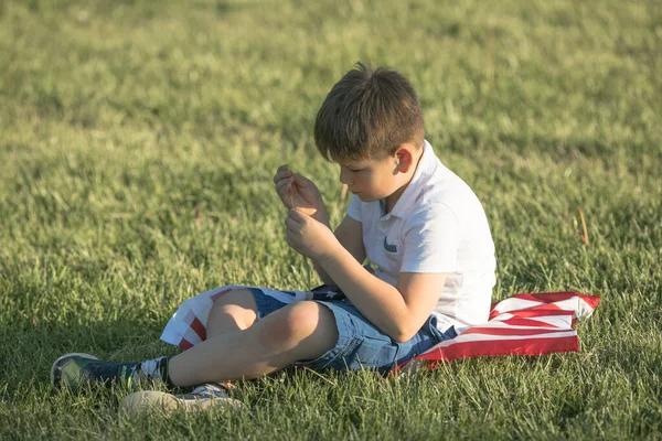 アメリカ独立記念日の7月4日を祝う子供の男の子 小麦畑をアメリカの国旗で走る子供 — ストック写真