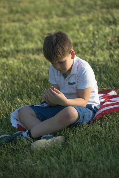 アメリカ独立記念日の7月4日を祝う子供の男の子 小麦畑をアメリカの国旗で走る子供 — ストック写真