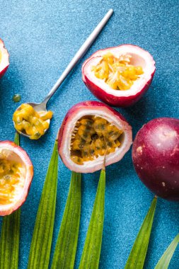 Olgun tutku meyvesi, yarım ve mavi arka planda bir dilim meyve..