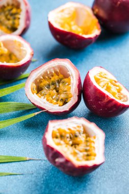 Olgun tutku meyvesi, yarım ve mavi arka planda bir dilim meyve..