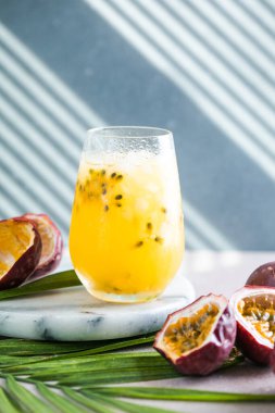 Limonlu ve tutkulu meyveli buzlu meyve suyu. Arka planda yarım dilim, ferahlatıcı içecek ya da buzlu içecek.