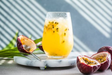 Limonlu ve tutkulu meyveli buzlu meyve suyu. Arka planda yarım dilim, ferahlatıcı içecek ya da buzlu içecek.