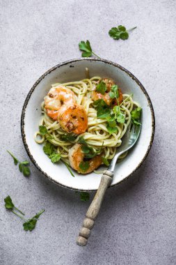 Birkaç porsiyon haşlanmış ve kıvrılmış karides kuyruklu makarna.