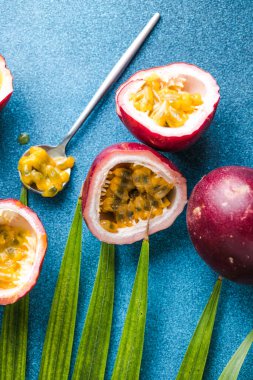 Olgun tutku meyvesi, yarım ve mavi arka planda bir dilim meyve..