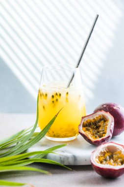 Olgun çarkıfelek meyvesi, yarım ve bir dilim meyve beyaz arka planda.