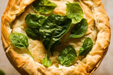 Tahta tahtada ıspanaklı ve peynirli Yunan turtası. Karanlık arka plan. Üst görünüm