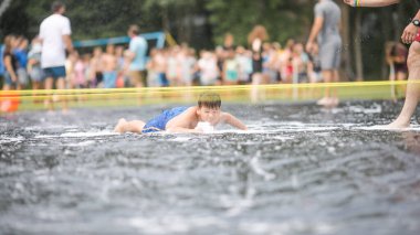 Çocuklar suyla oynar, çocuk sabun köpüğünde yüzer. Çocuklar için yaz bahçesi eğlencesi. Güneşli bir günde su sıçrayan çocuk.. 
