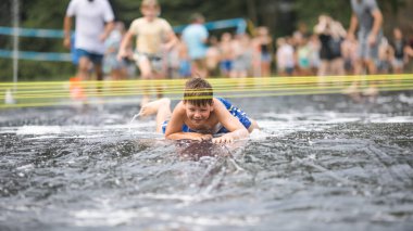 Çocuklar suyla oynar, çocuk sabun köpüğünde yüzer. Çocuklar için yaz bahçesi eğlencesi. Güneşli bir günde su sıçrayan çocuk.. 