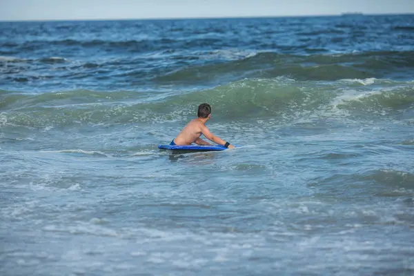 陽気な10代の少年が水泳ボードを持っている ハッピーヨーロッパの家族は暑い夏の日に海に浮かぶ楽しさを持っています — ストック写真