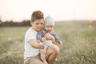Dışarıda sevimli çocuklar var, ağabeyi daha genç sarılıyor, kardeşiyle ilgileniyor. Kavramsal kardeşlik ve samimi yaşam tarzı