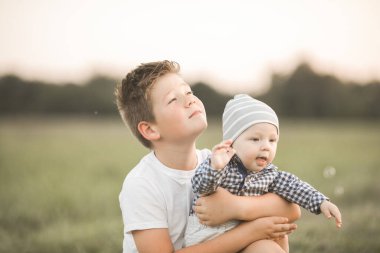 Dışarıda sevimli çocuklar var, ağabeyi daha genç sarılıyor, kardeşiyle ilgileniyor. Kavramsal kardeşlik ve samimi yaşam tarzı