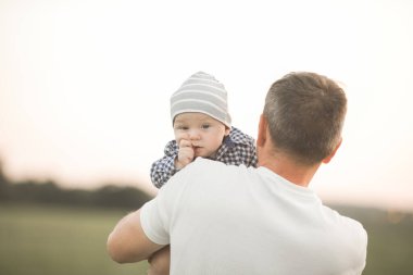Baba ve oğlu, küçük bebek. Dışarıda mutlu ve sevgi dolu bir aile. Babalar Günü kavramı.