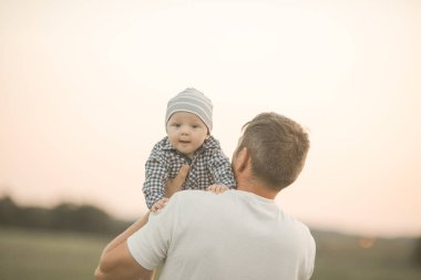 Baba ve oğlu, küçük bebek. Dışarıda mutlu ve sevgi dolu bir aile. Babalar Günü kavramı.