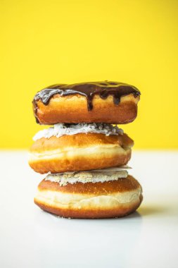 Farklı renkte tatlı çörekler renkli bir arka planda büyük bir yığın içinde yatıyor.