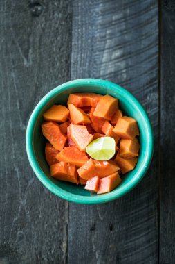 Mutfak masasında dilimlenmiş papaya. Meyveli portakallı papaya yemeye hazır..