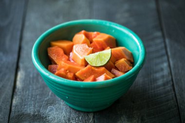 Mutfak masasında dilimlenmiş papaya. Meyveli portakallı papaya yemeye hazır..