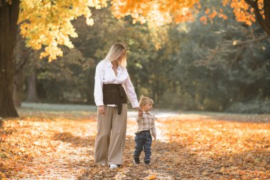 Anneler günü, aileleri severim. Doğada sonbahar yürüyüşü yapan bir aile. Anne ve çocuğu şefkatle sarılıyorlar.