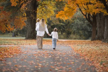 Anneler günü, aileleri severim. Doğada sonbahar yürüyüşü yapan bir aile. Anne ve çocuğu şefkatle sarılıyorlar.
