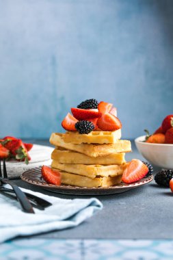 Waffle ve çilek bir tabağa istiflenmiş. Belçika ev yapımı waffle 'lar