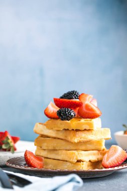 Waffle ve çilek bir tabağa istiflenmiş. Belçika ev yapımı waffle 'lar