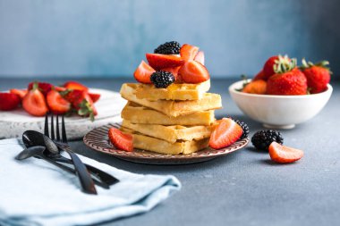 Waffle ve çilek bir tabağa istiflenmiş. Belçika ev yapımı waffle 'lar