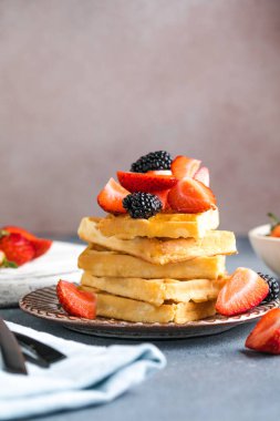 Waffle ve çilek bir tabağa istiflenmiş. Belçika ev yapımı waffle 'lar