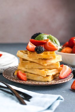 Waffle ve çilek bir tabağa istiflenmiş. Belçika ev yapımı waffle 'lar