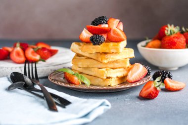 Waffle ve çilek bir tabağa istiflenmiş. Belçika ev yapımı waffle 'lar