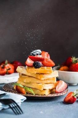 Waffle ve çilek bir tabağa istiflenmiş. Belçika ev yapımı waffle 'lar