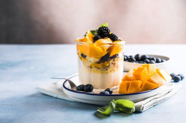 Böğürtlenli, kremalı tatlı ve ahşap masa. Boşluğu kopyala