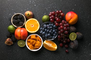 Beton masa üzerinde taze egzotik meyve ve dut çeşitleri, düz yatıyordu