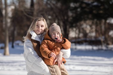 Parkta yürüyen mutlu anne ve çocuklar. Soğuk havada dışarıda oynayan mutlu bir aile. Aile, annelik, insanlar ve tatil kavramı.