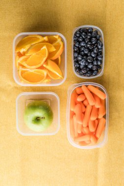 Sağlıklı atıştırmalıklarla dolu beslenme çantası. Meyve ve sebzeli plastik kap, yakın plan..