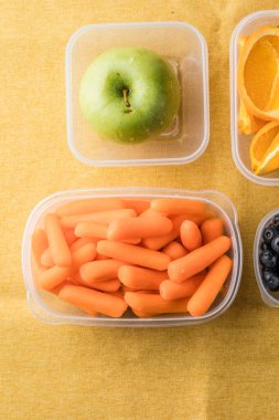 Sağlıklı atıştırmalıklarla dolu beslenme çantası. Meyve ve sebzeli plastik kap, yakın plan..