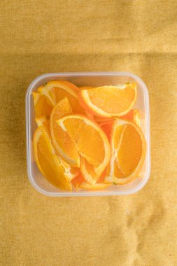 Plastik şeffaf konteyner kutusunda turuncu dilim