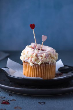 Krem peynirli ve çilekli kekler. Beton bir masada Sevgililer Günü için kekler.