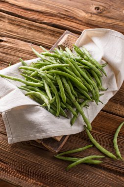 Taze taze fasulye kabukları. Eski ahşap arka plan. Yeşil çalı fasulyesi hasatı