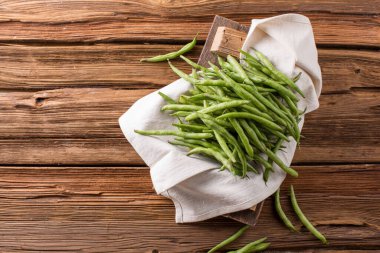 Taze taze fasulye kabukları. Eski ahşap arka plan. Yeşil çalı fasulyesi hasatı