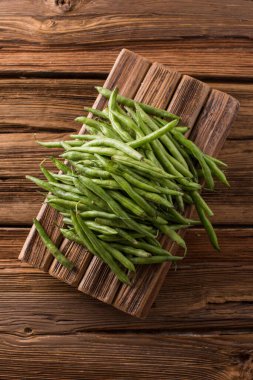 Taze taze fasulye kabukları. Eski ahşap arka plan. Yeşil çalı fasulyesi hasatı
