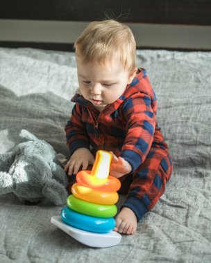 Elinde oyuncaklar ve piramitlerle şaşırmış bir çocuk.