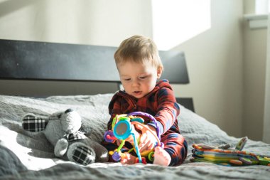 Elinde oyuncaklar ve piramitlerle şaşırmış bir çocuk.