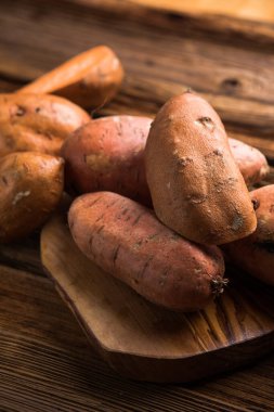 surowego słodkie ziemniaki na drewniane tł