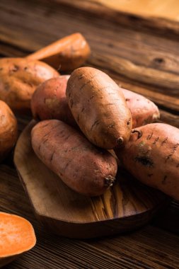 surowego słodkie ziemniaki na drewniane tł
